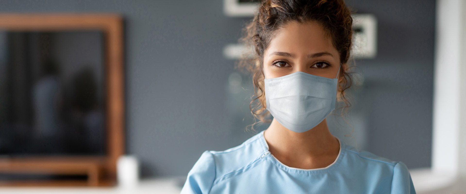 FEMALE DOCTOR LOOKING TO CAMERA