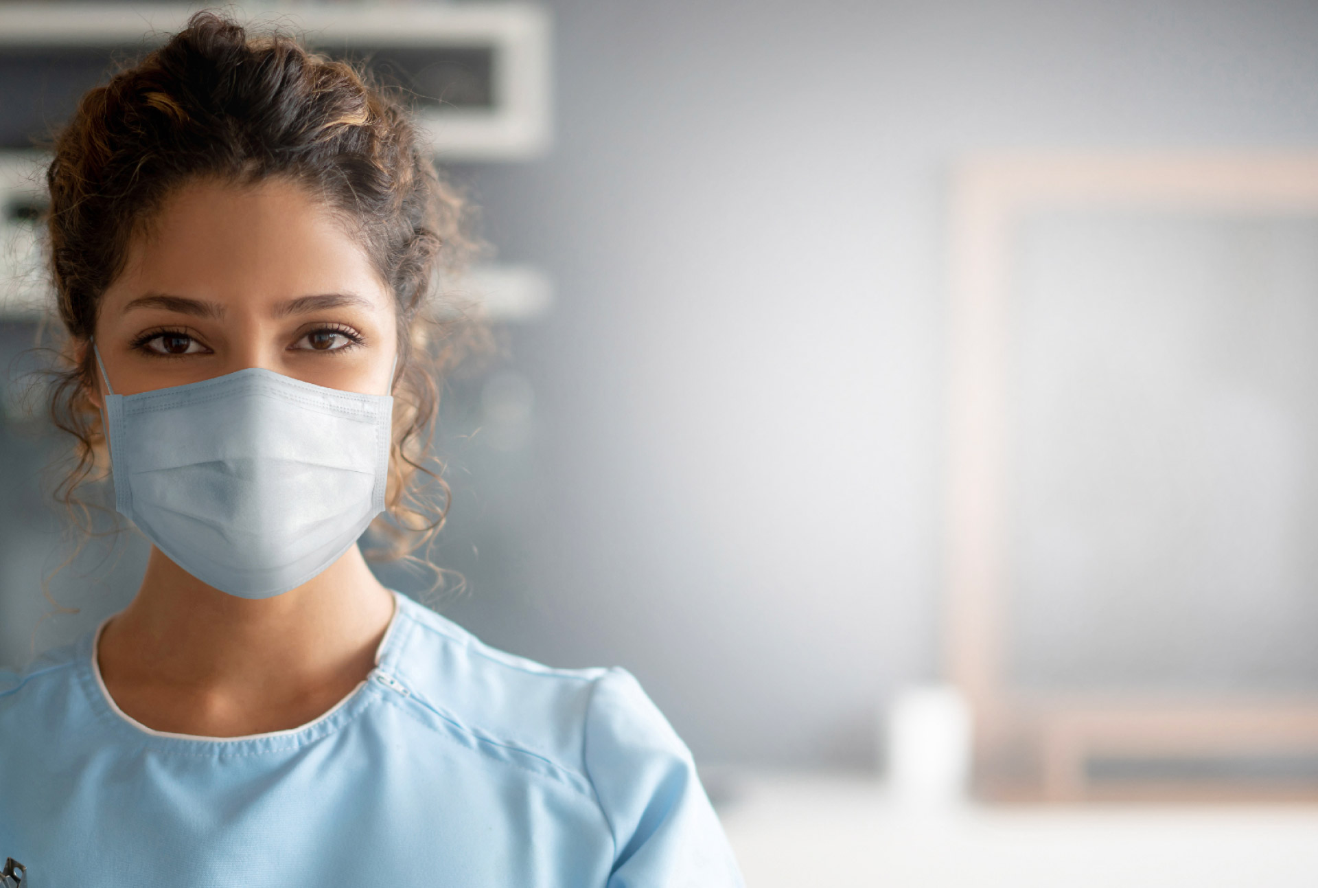 WOMAN IN MASK AND SCRUBS