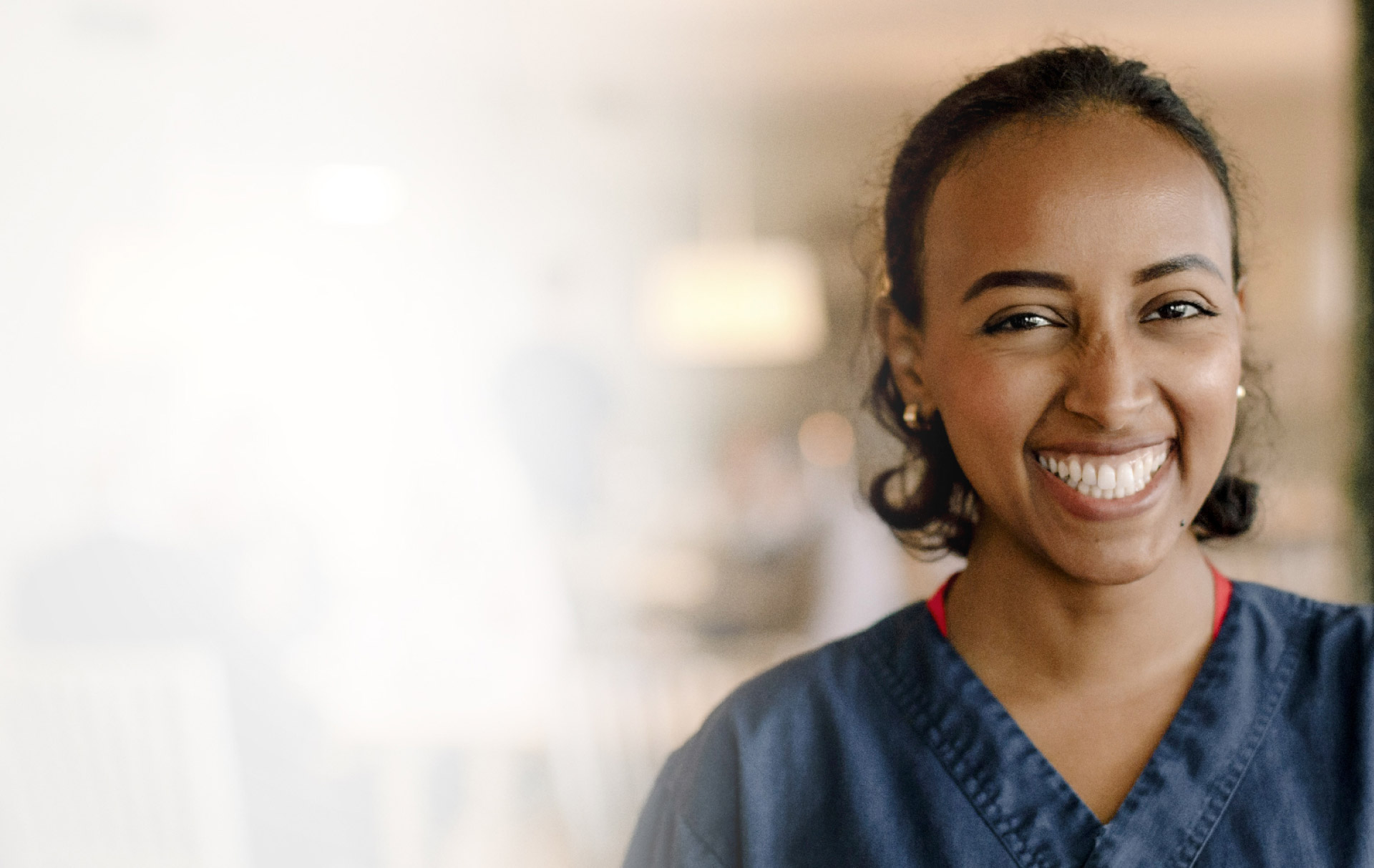 WOMAN IN SCRUBS SMILING