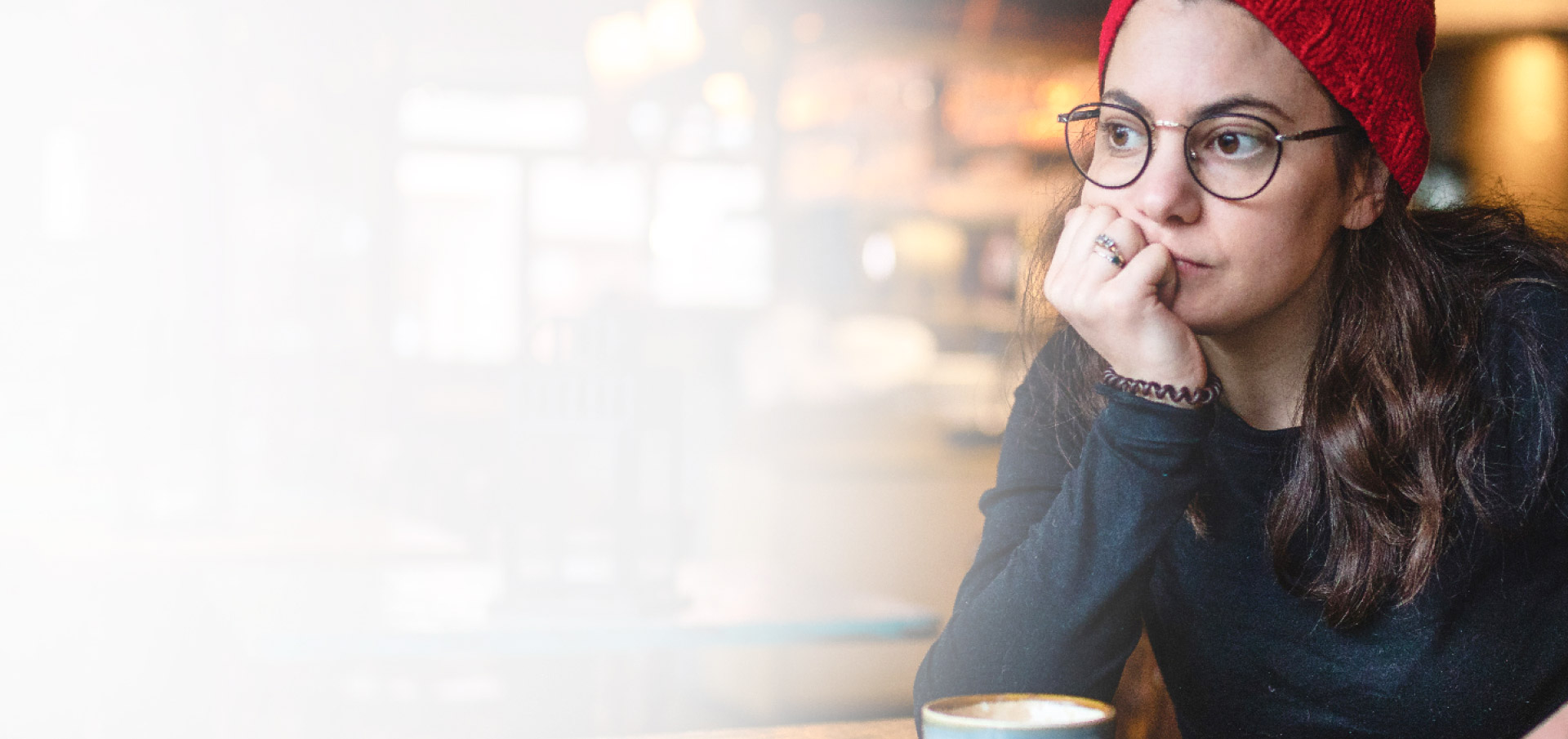 WOMAN IN CAFÉ LOOKING SAD