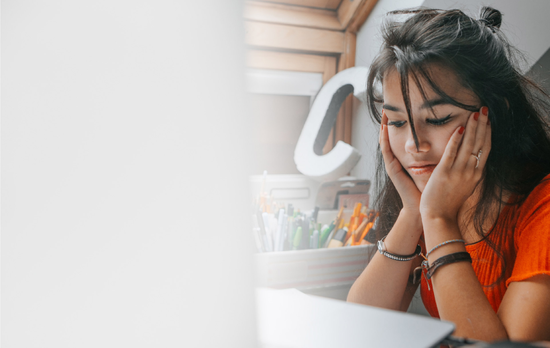 WOMAN LOOKING AT HER LAPTOP WITH HER FACE IN HER HANDS