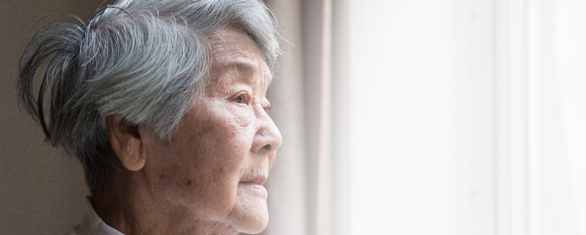SENIOR WOMAN LOOKING OUT THE WINDOW