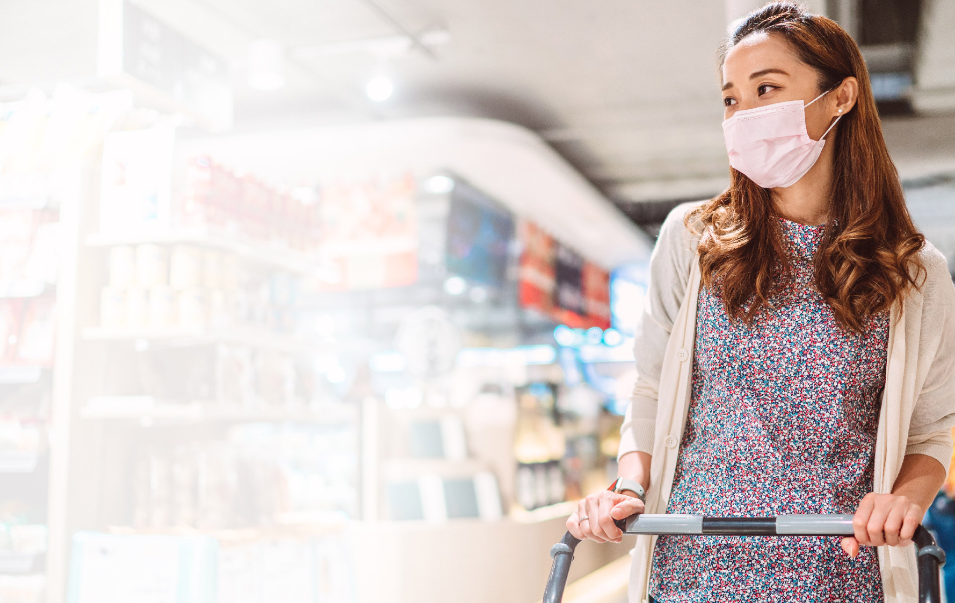 WOMAN IN MASK PUSHING GROCERY CART
