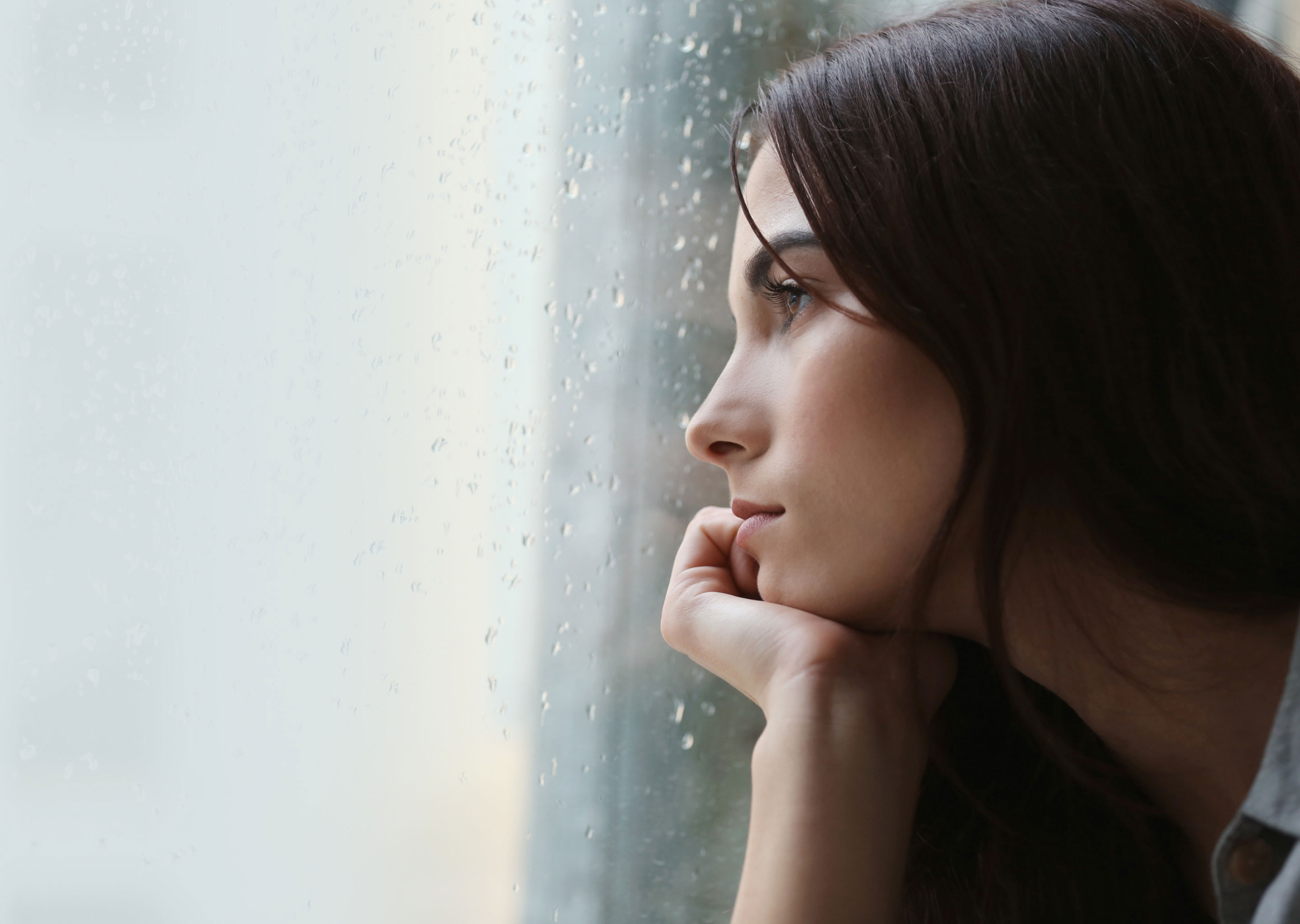 woman looking out a rainy window