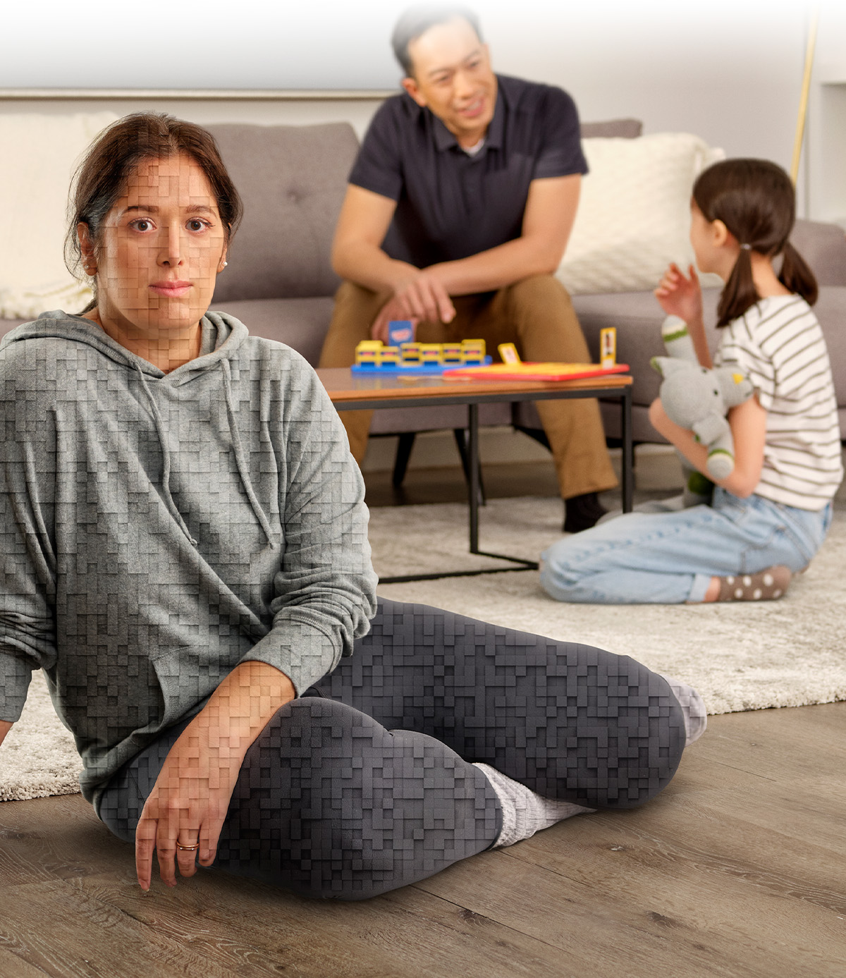 Une femme est assise par terre dans son salon avec sa famille, et la légende suivante apparaît : « Parlez à votre médecin de Trintellix ». La femme à l’avant-plan se compose de pixels tridimensionnels.