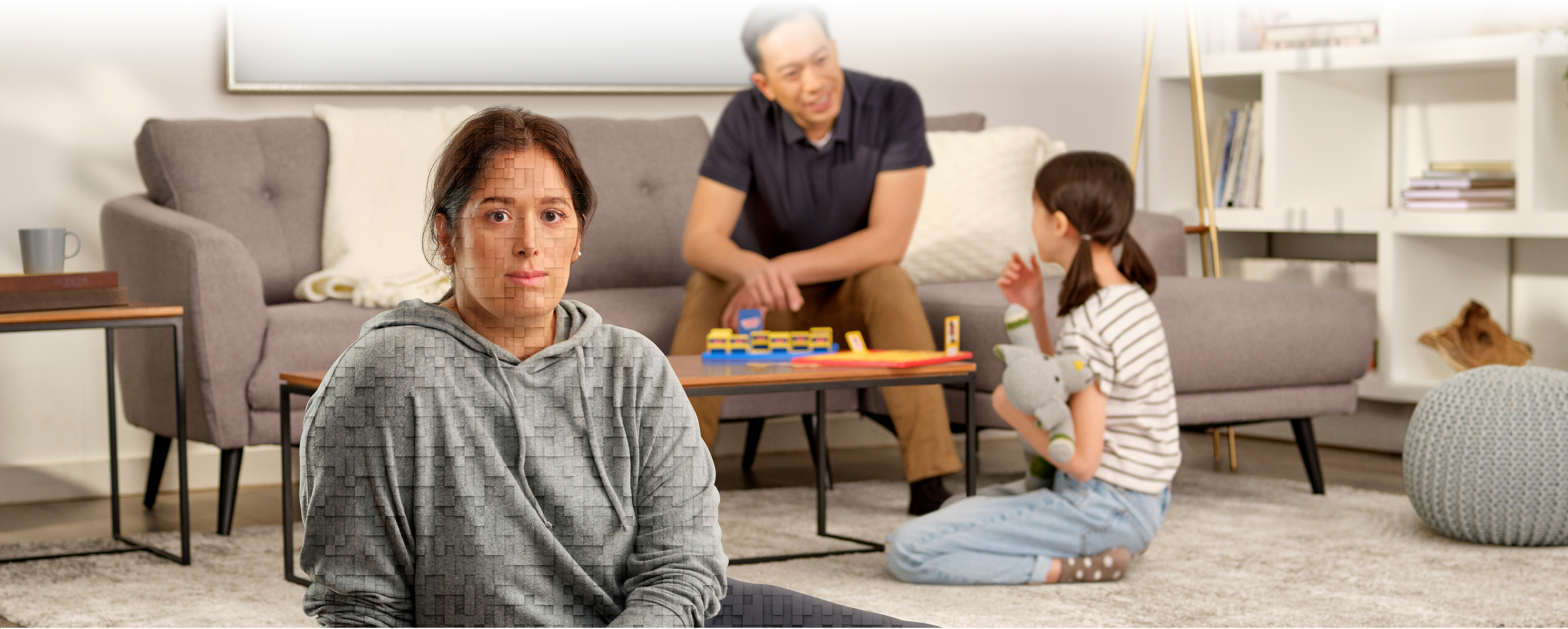 Une femme est assise par terre dans son salon avec sa famille, et la légende suivante apparaît : « Parlez à votre médecin de Trintellix ». La femme à l’avant-plan se compose de pixels tridimensionnels.