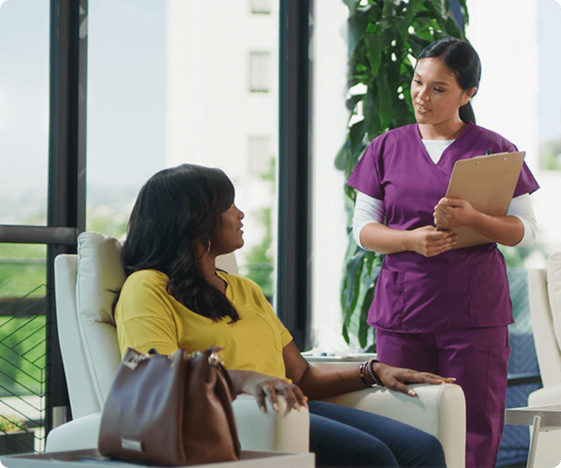 Healthcare provider with file talking to a seated woman image