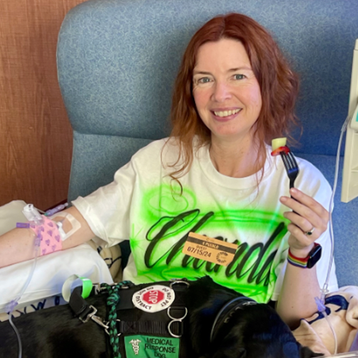 Chanda, VYEPTI® patient, sitting in a chair while receiving her infusion.